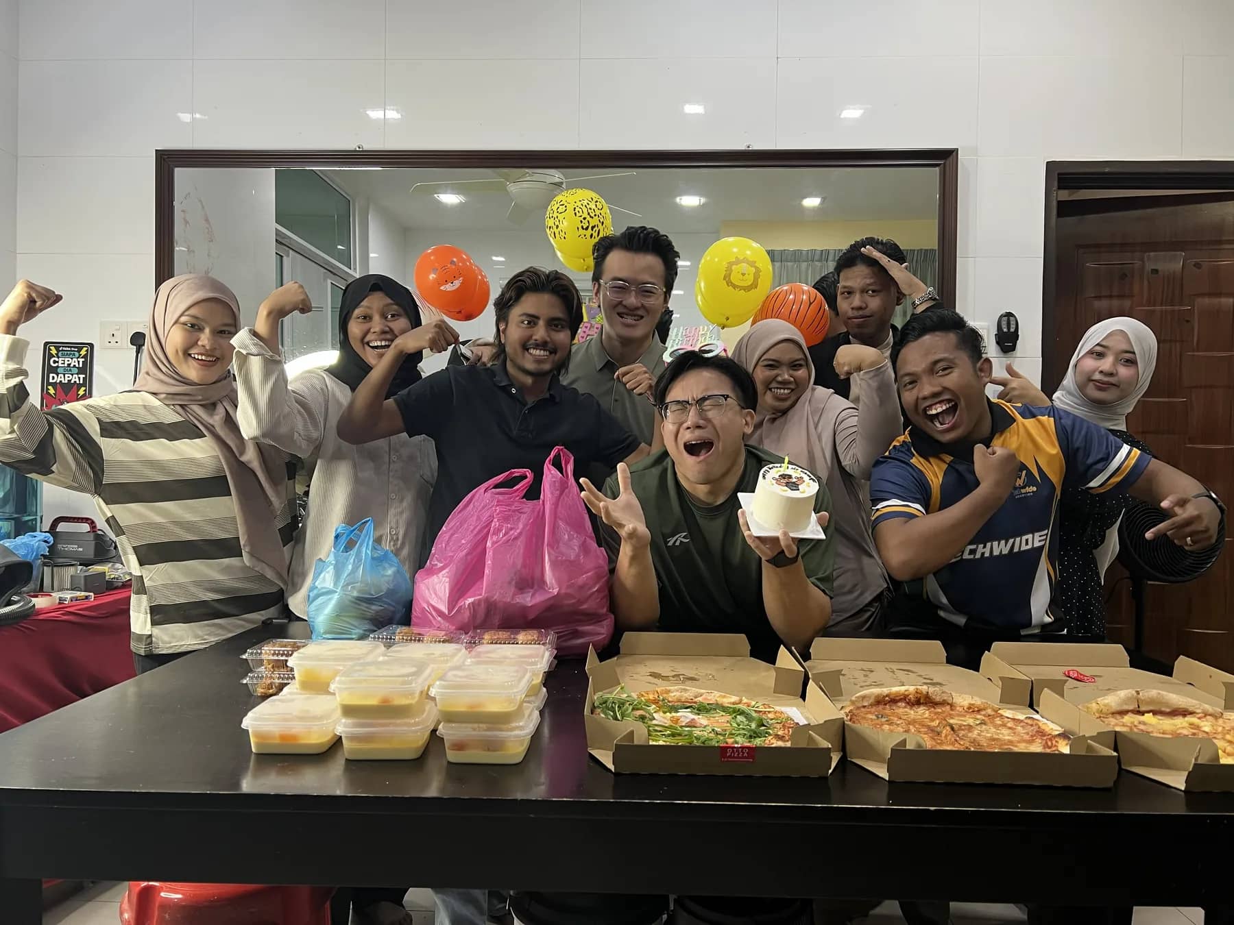 Office birthday celebration with cake and balloons